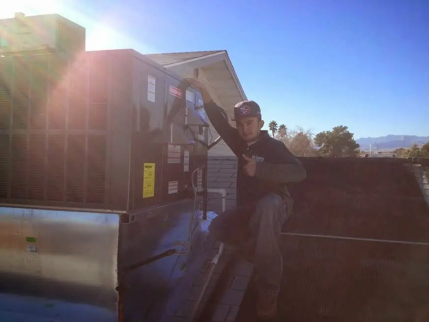 HVAC technician performing AC Tune-Up on a rooftop unit in Hyattsville